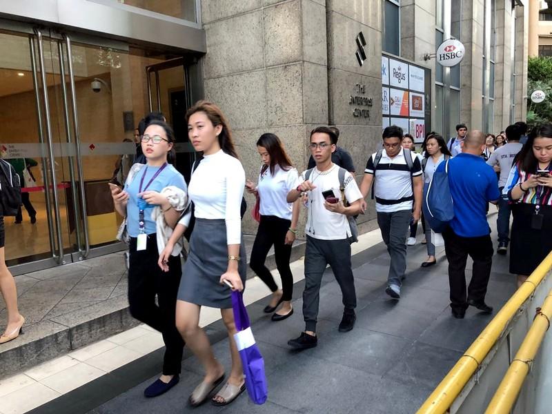 Employees walk outside after being evacuated from the office building after an earthquake in Makati City, Philippines.