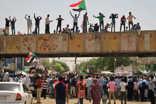 Sudanese protesters, waving a national flag, take part in a sit-in outside the army headquarters in Khartoum on May 5, 2019, as thousands of people remain encamped in the area to demand the current 10-member army council that took power after the ouster of the country's former president be replaced by a civilian administration. - Sudanese mediators facilitating talks between the army rulers and protest leaders have proposed the country have two transition councils, with one led by generals overseeing security, according to a senior opposition leader and member of the umbrella protest group the Alliance for Freedom and Change.