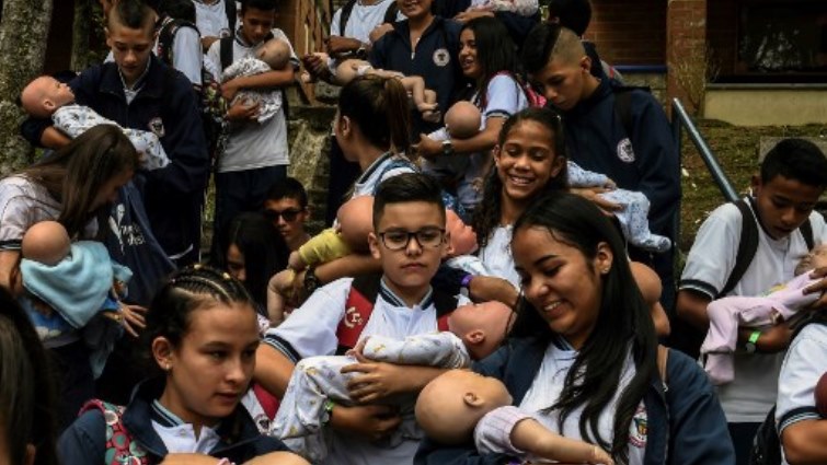 Teenage students carry baby robots during break at a school in Caldas, Antioquia, Colombia.