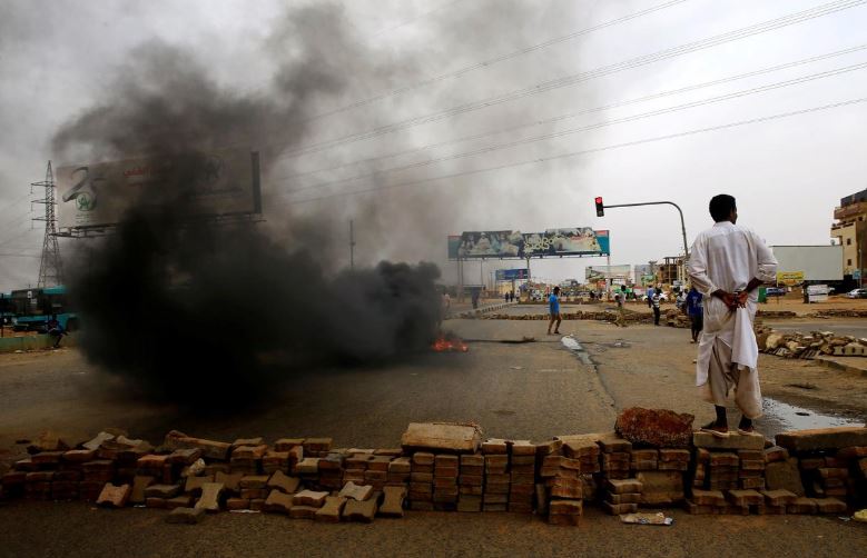 A Sudanese protester stands near a barricade on a street, demanding that the country's Transitional Military Council handover power to civilians, in Khartoum, Sudan.