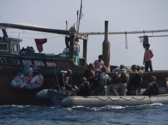 The United States Navy search and seizure team from The Arleigh Burke-class guided-missile destroyer USS McFaul's (DDG 74) speak to fishermen aboard a Bahraini dhow during routine maritime security operations in Arabian Sea.