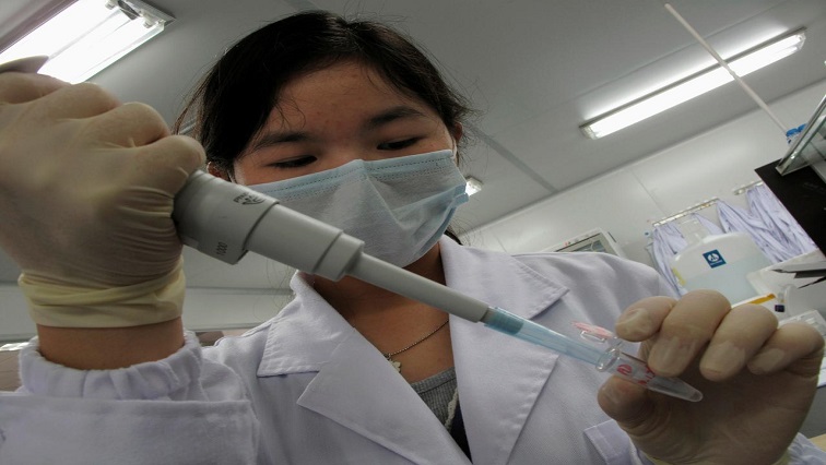 A researcher inserts a sample into a receptacle inside the "DNA Lab".