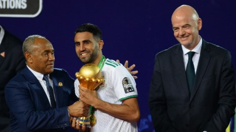 Fifa President Gianni Infantino (R) and Confederation of African Football (CAF) President Ahmad Ahmad (L) hand over the trophy to Algeria's forward Riyad Mahrez after the 2019 CAN Final.