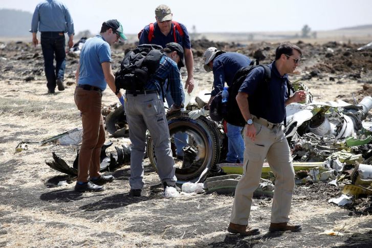 American civil aviation and Boeing investigators search through the debris at the scene of the Ethiopian Airlines Flight ET 302 plane crash.