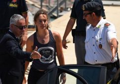 Carola Rackete, the 31-year-old Sea-Watch 3 captain, disembarks from a Finance police boat and is escorted to a car, in Porto Empedocle.