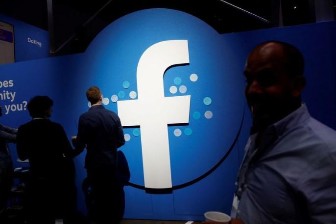 Attendees walk past a Facebook logo in San Jose, California.