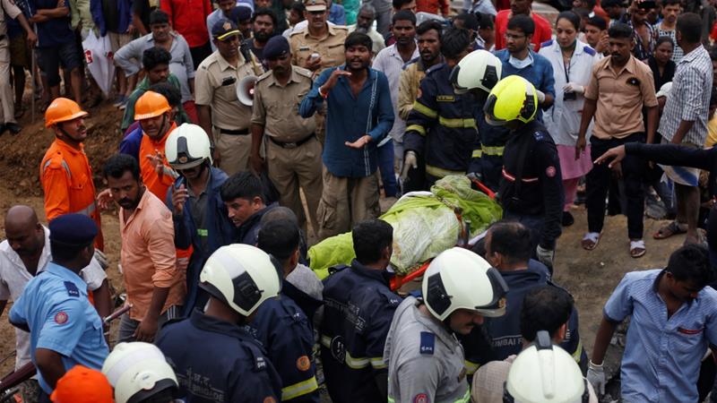 Rescue workers carry the body of a victim after a wall collapsed at a slum in Mumbai, India.