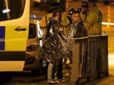 Two women wrapped in thermal blankets stand near the Manchester Arena, where U.S. singer Ariana Grande had been performing, in Manchester.