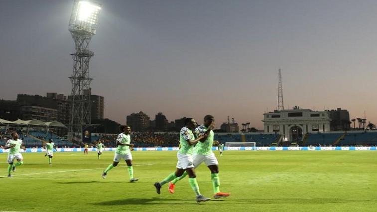 Nigerian football players running on the field