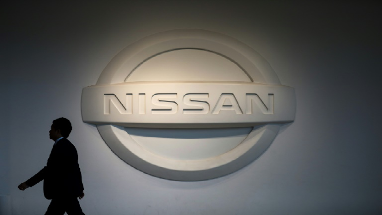 Man walks past Nissan logo