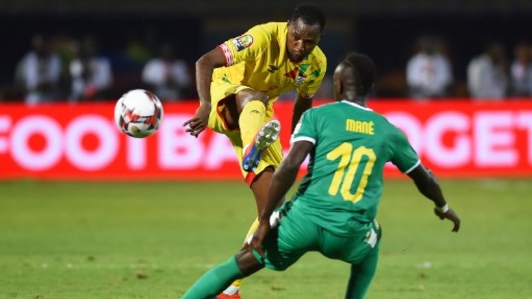 Benin's defender Seidou Baraze (L) is marked by Senegal's forward Sadio Mane.