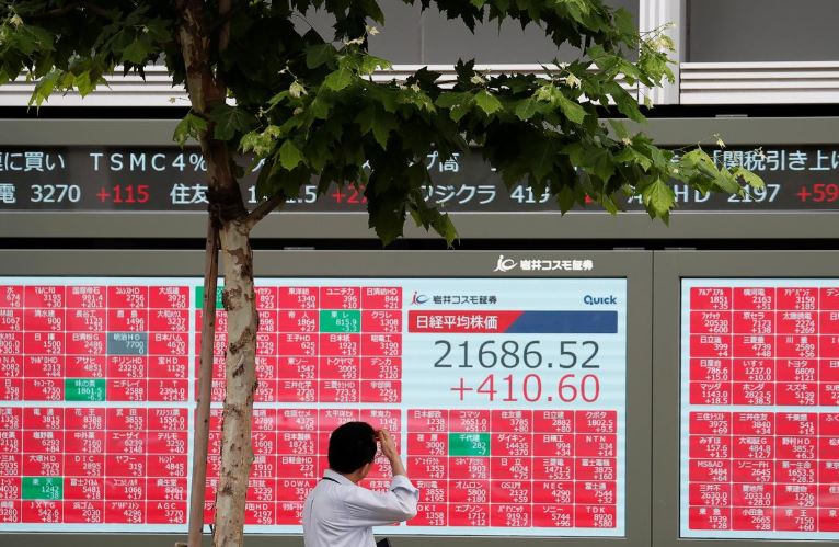 A man looks at a stock quotation board outside a brokerage in Tokyo
