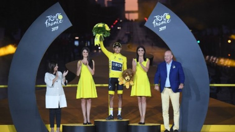 Colombia's Egan Bernal (C) celebrates his overall leader's yellow jersey on the podium.