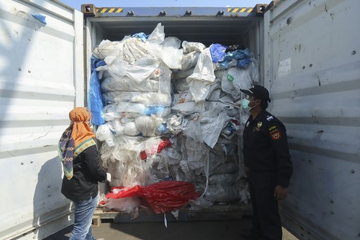 Indonesian officers check a container full with illegal imported plastics waste in Batam on July 29, 2019. Indonesia has returned seven shipping containers of illegally imported waste to France and Hong Kong, an official.