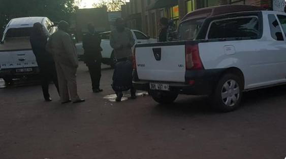 Police clean blood off the pavement outside a supermarket in Mokopane where two ANC officials from the Mogalakwena branch where shot and killed.
