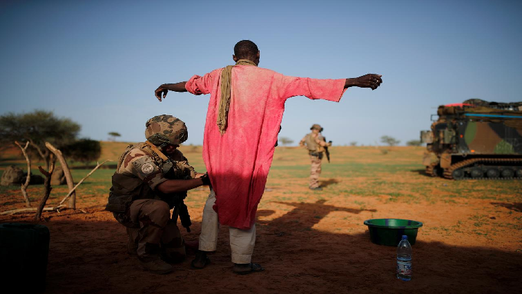 A French soldier of the 2nd Foreign Engineer Regiment searches a man during an area control operation in the Gourma region during Operation Barkhane in Ndaki, Mali.