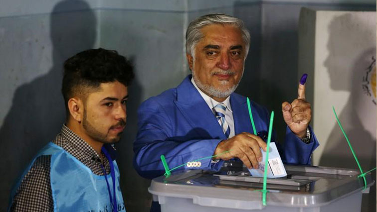 Afghan presidential candidate Abdullah Abdullah poses as he casts his vote at a polling station in Kabul, Afghanistan