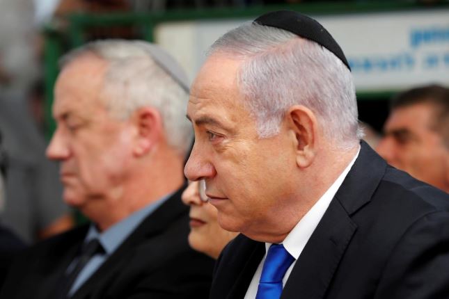 Israeli Prime Minister Benjamin Netanyahu looks on as he sits next to Benny Gantz, leader of the Blue and White party, during a memorial ceremony for late Israeli President Shimon Peres, at Mount Herzl in Jerusalem.