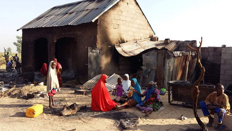 People sit near a burnt house after an attack by suspected members of the Islamist Boko Haram insurgency in Bulabulin village, Nigeria November 1, 2018. (File Image)