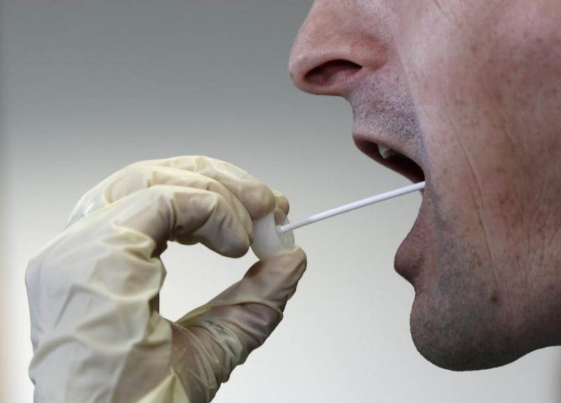 A German police officer takes a saliva sample from a man during a DNA mass screening of about 3000 men.