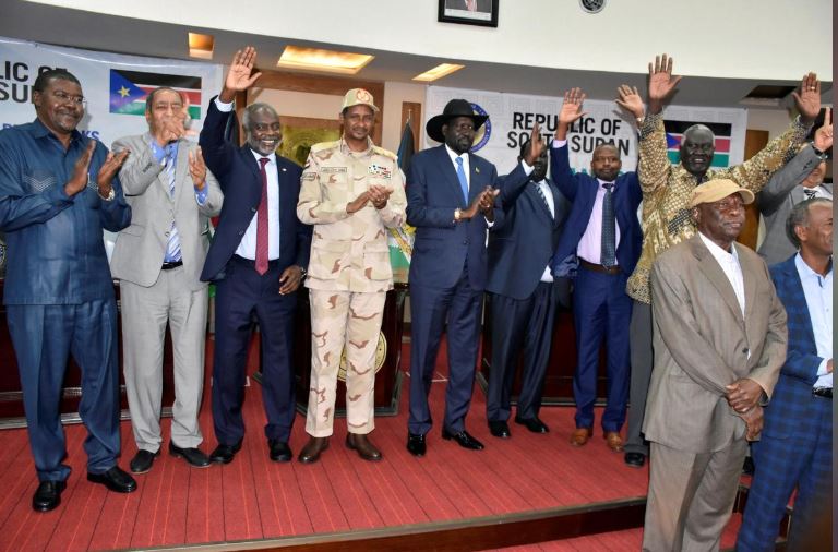 Sudanese officials, rebels and diplomats react after signing the initial agreement on a roadmap for peace talks in Juba, South Sudan.