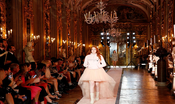 Plus-size model walks on catwalk wearing a short-fronted, long-back pink tulle dress during fashion show to present creations of designer Giambattista Valli and fast-fashion giant H&M.
