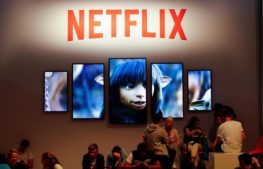 Gamers and visitors take a rest at the booth of Netflix during Europe's leading digital games fair Gamescom.