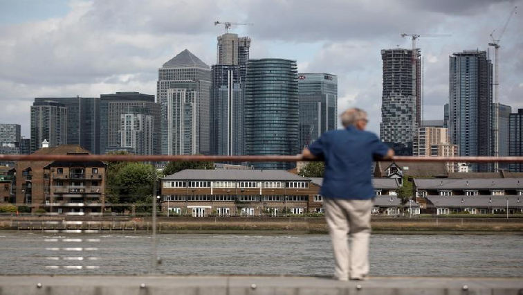 A man looks out onto the Canary Wharf financial district in London, Britain