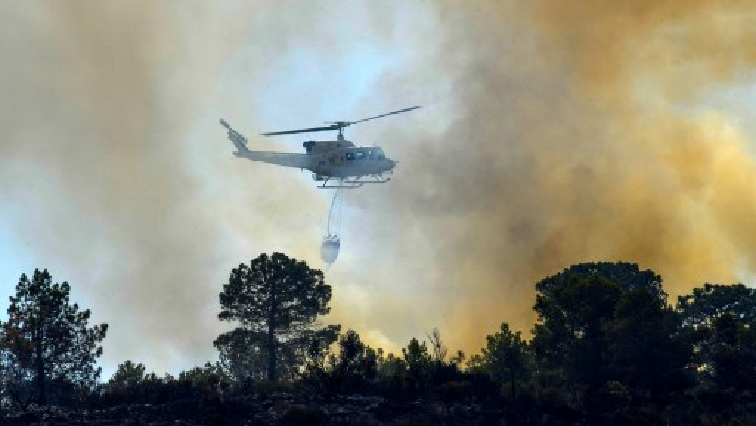 A firefighting helicopter is seen trying to exterminate a veldfire in Houwhoek. (File photo)