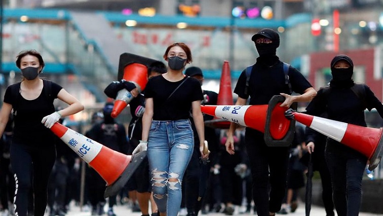 Protesters walk down the road with traffic cones to build a barricade in Causeway Bay, Hong Kong.