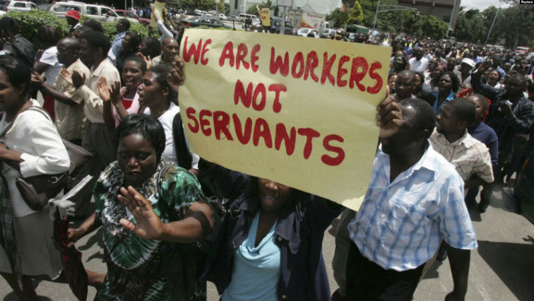 (FILE) Zimbabwe's civil servants carry placards as they march during a protest in the streets of the capital Harar.