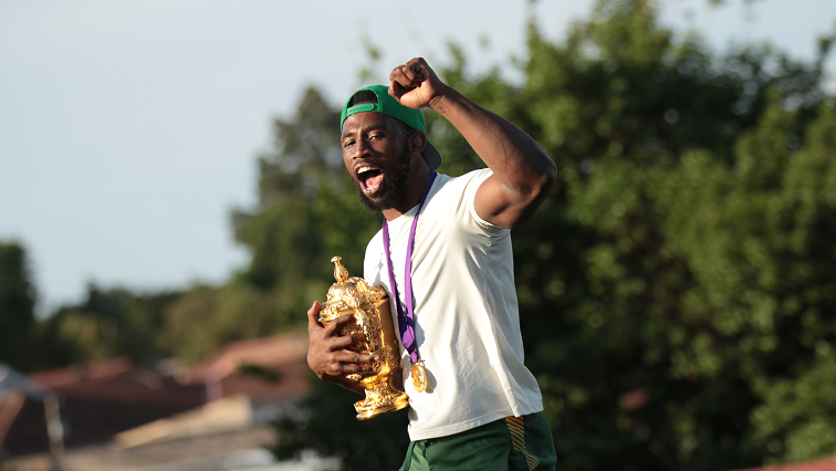 Springboks Captain, Siya Kolisi holds his fist up and hugs the Webb Ellis Cup as he acknowledges the Soweto crowd during their trophy tour.