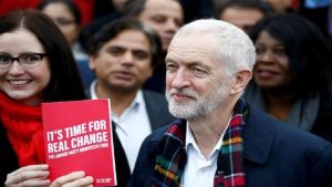 Britain's opposition Labour Party leader Jeremy Corbyn poses with his party's manifesto as he visits Labour activists.