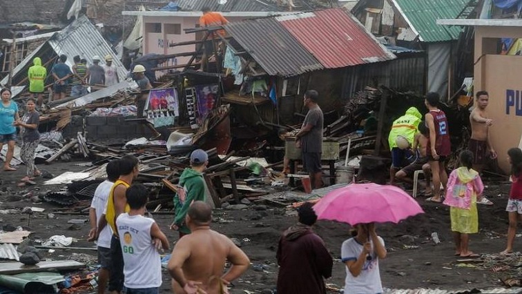 Residents stand among their damaged houses after Typhoon Kammuri hit Legazpi City, Albay, Philippines.