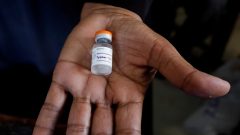 A medical staff member holds a bottle of anti-typhoid vaccine to be given to children during the immunisation campaign at a school.