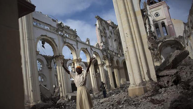 A woman prays among the rubble of the damaged main cathedral in downtown Port-au-Prince.