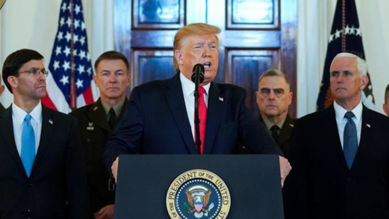U.S. President Donald Trump delivers a statement about Iran flanked.