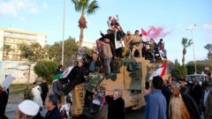 Supporters of Libyan National Army (LNA) commanded by Khalifa Haftar, celebrate on top of a Turkish military armored vehicle, which LNA said they confiscated during Tripoli clashes, in Benghazi.
