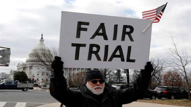 An activist holds up a sign during a rally calling for witnesses in the Senate Impeachment trial of US President Donald Trump in Washington, United States on 29 January 2020.