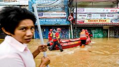 Members of a rescue team prepare an inflatable boat to evacuate locals as floods hit the Jatinegara area after heavy rains in Jakarta