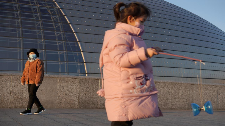 A girl wearing a face mask plays with a diabolo near the National Centre for the Performing Arts, following an outbreak of the novel coronavirus in Beijing, China.