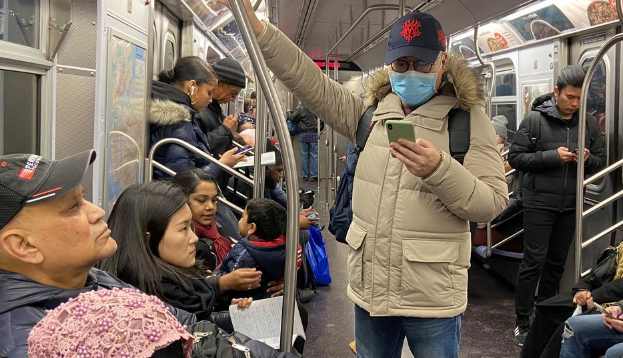 A man with a face mask rides the subway in the Queens borough of New York City.