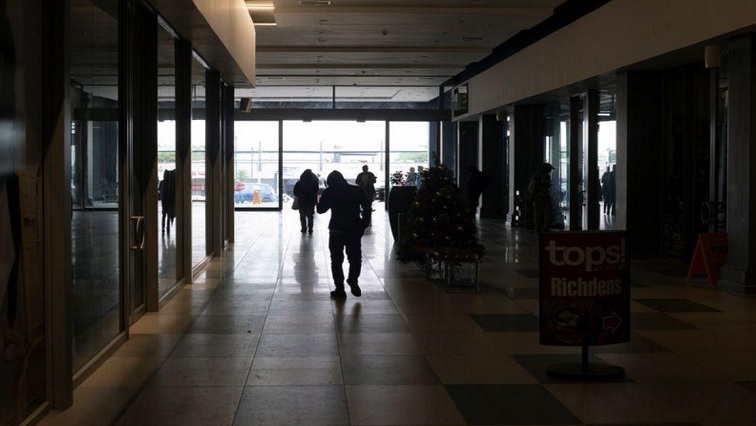 People walk in a shopping mall during an electricity load-shedding blackout in Hillcrest, South Africa, December 10, 2019.