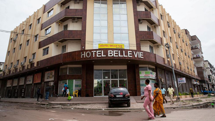 Women walk past the Belle Vie Hotel which is under quarantine after it was suspected that Congo's first confirmed coronavirus patient was staying in it, in Kinshasa, Democratic Republic of Congo