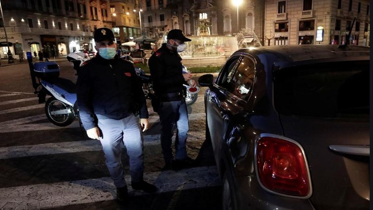 Police officers wear protective face masks at a checkpoint on the second day of an unprecedented lockdown across all of the country, imposed to slow the outbreak of coronavirus, in Naples, Italy.