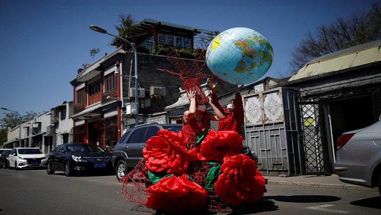 Artist Kong Ning, wearing a face mask following the coronavirus disease (COVID-19) outbreak, prepares for a portrait in a wearable art piece she made to mark Earth Day, during a Reuters interview outside her studio in Beijing, China April 22, 2020.
