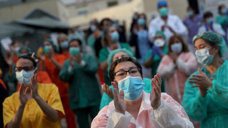 Medical staff from Gregorio Maranon hospital react as neighbours applaud from their homes in support for healthcare workers, amid the coronavirus disease (COVID-19) outbreak, in Madrid, Spain, April 6, 2020. REUTERS/Susana Vera