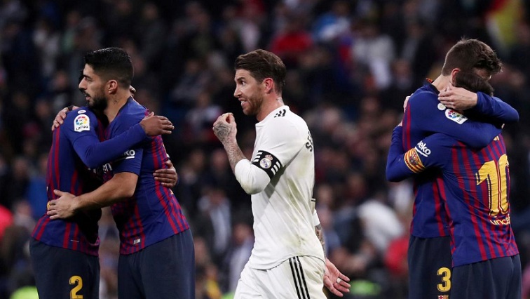 FC Barcelona's Lionel Messi, Luis Suarez and Gerard Pique celebrate victory as Real Madrid's Sergio Ramos walks off.