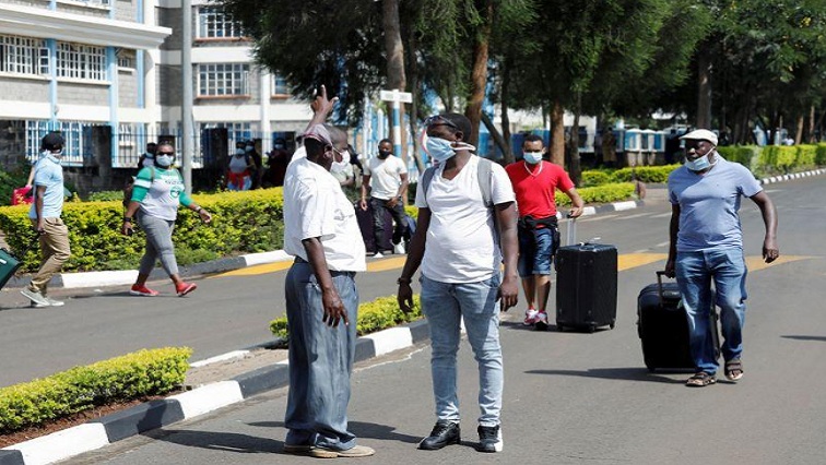 A security person points as he orders quarantined travellers protesting being held because of the coronavirus disease (COVID-19) outbreak for more than the usual 14 days at Kenyatta University near Nairobi, Kenya, on April 15, 2020.