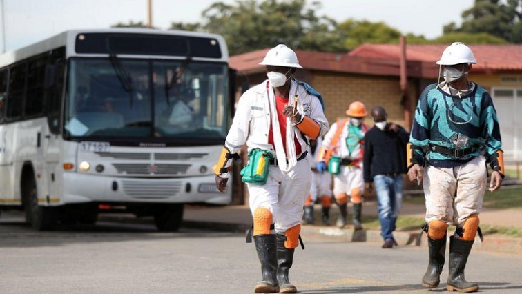 Mine workers wearing face masks arrive ahead of their shift, amid a nationwide coronavirus disease (COVID-19) lockdown, at a mine of Sibanye-Stillwater company in Carletonville, South Africa, May 19, 2020.